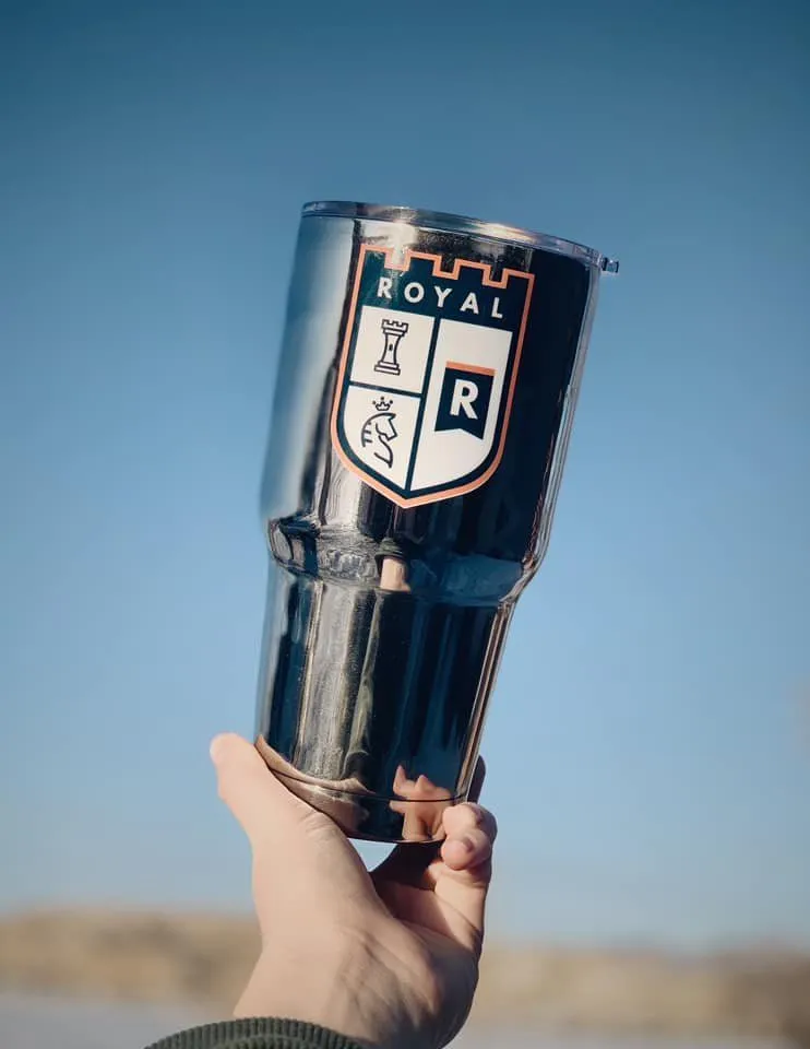 Royal tumbler held up against the sky